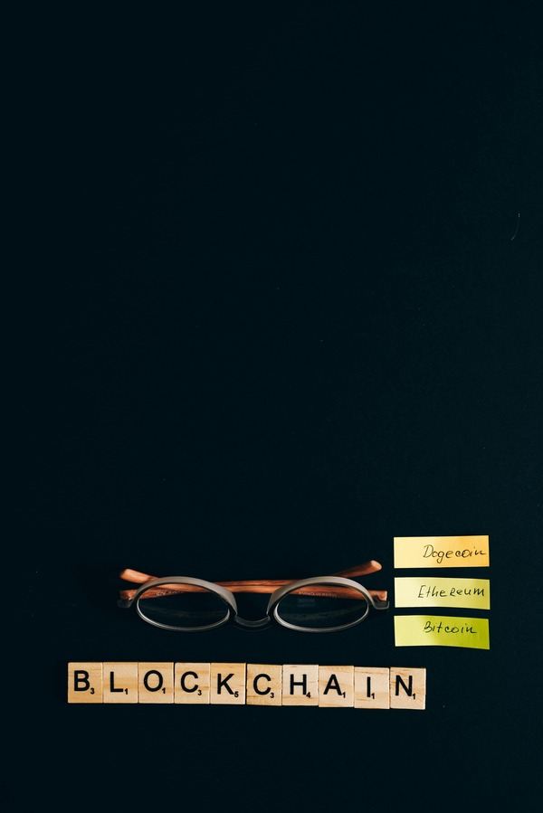 The word blockchain spelled with letter tiles next to glasses