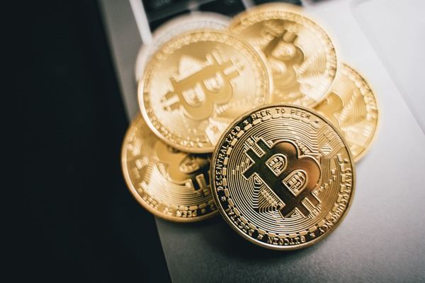Gold crypto coins stacked on a grey background