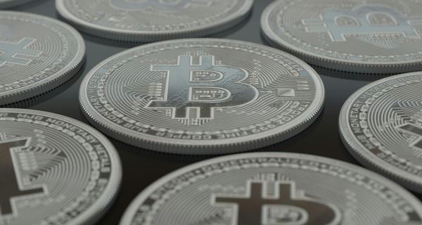 Rows of silver Bitcoin coins arranged closely together