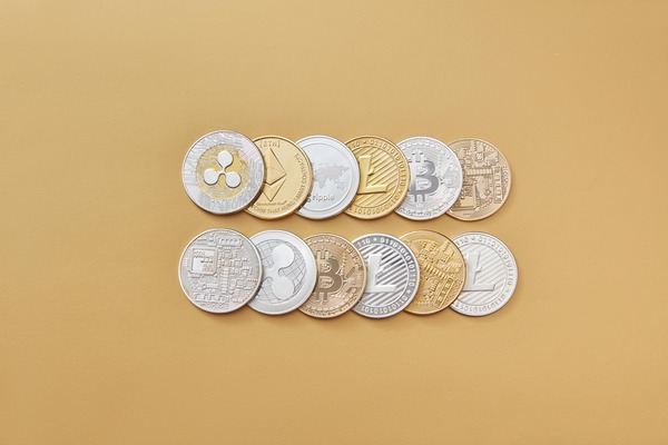 Row of assorted crypto coins on a beige background