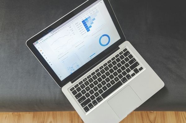 Laptop showing an analytics dashboard on a dark table