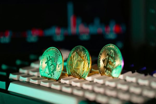 Glowing crypto coins standing on a backlit keyboard