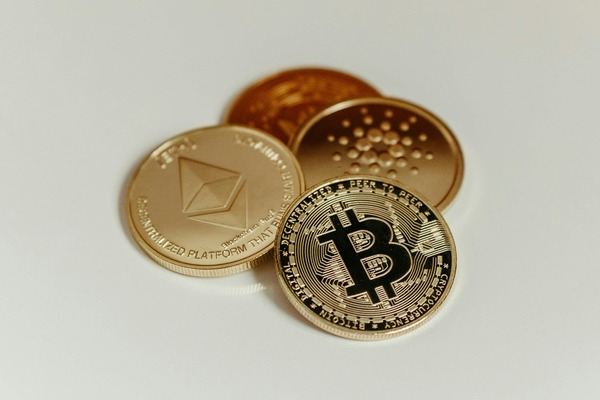 Ethereum, Bitcoin and Cardano coins on a white table
