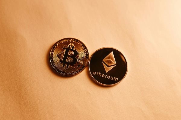 Bitcoin and Ethereum coins on a peach background